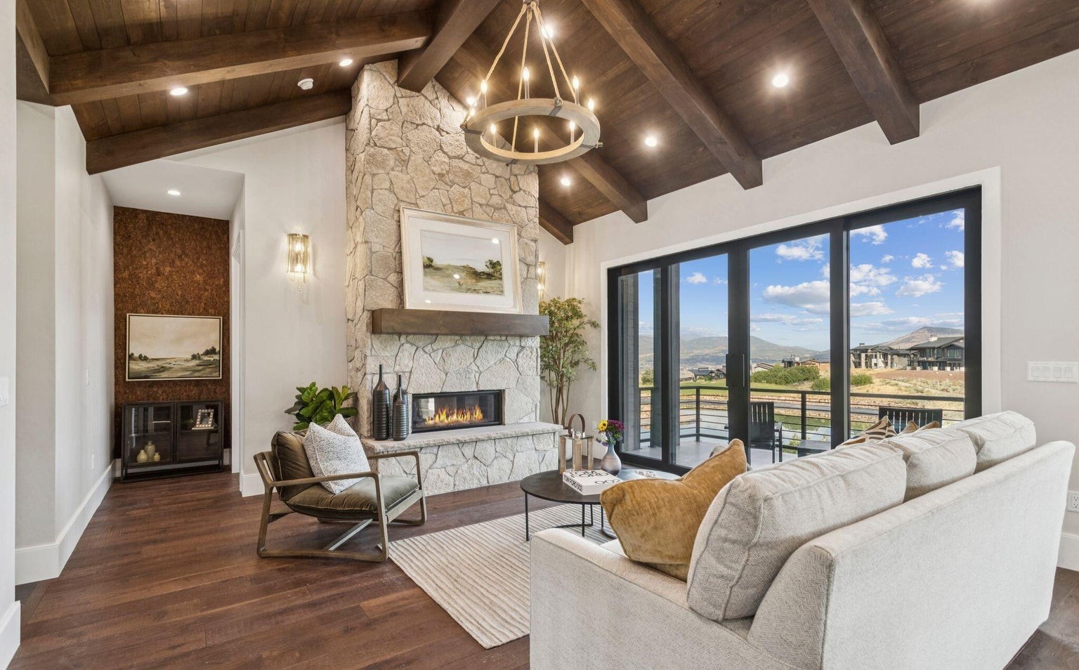 Great room with stone fireplace and vaulted wood beam ceiling
