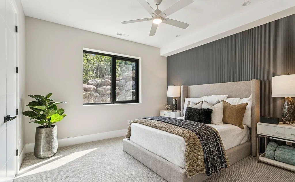 Guest bedroom with dark fluted accent wall and natural light