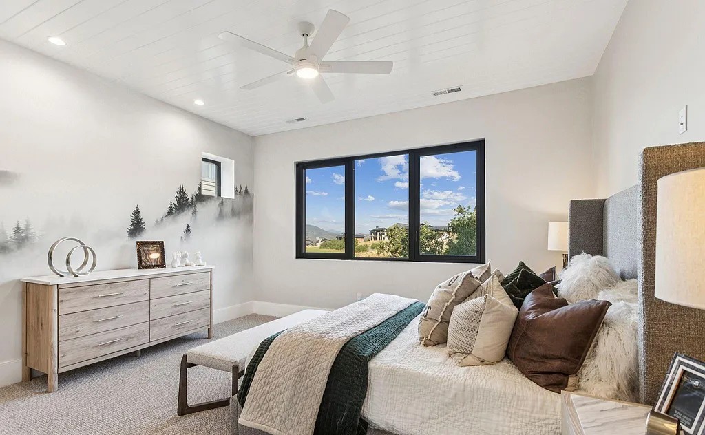 Bedroom with mountain mural accent wall, shiplap ceiling, and large windows
