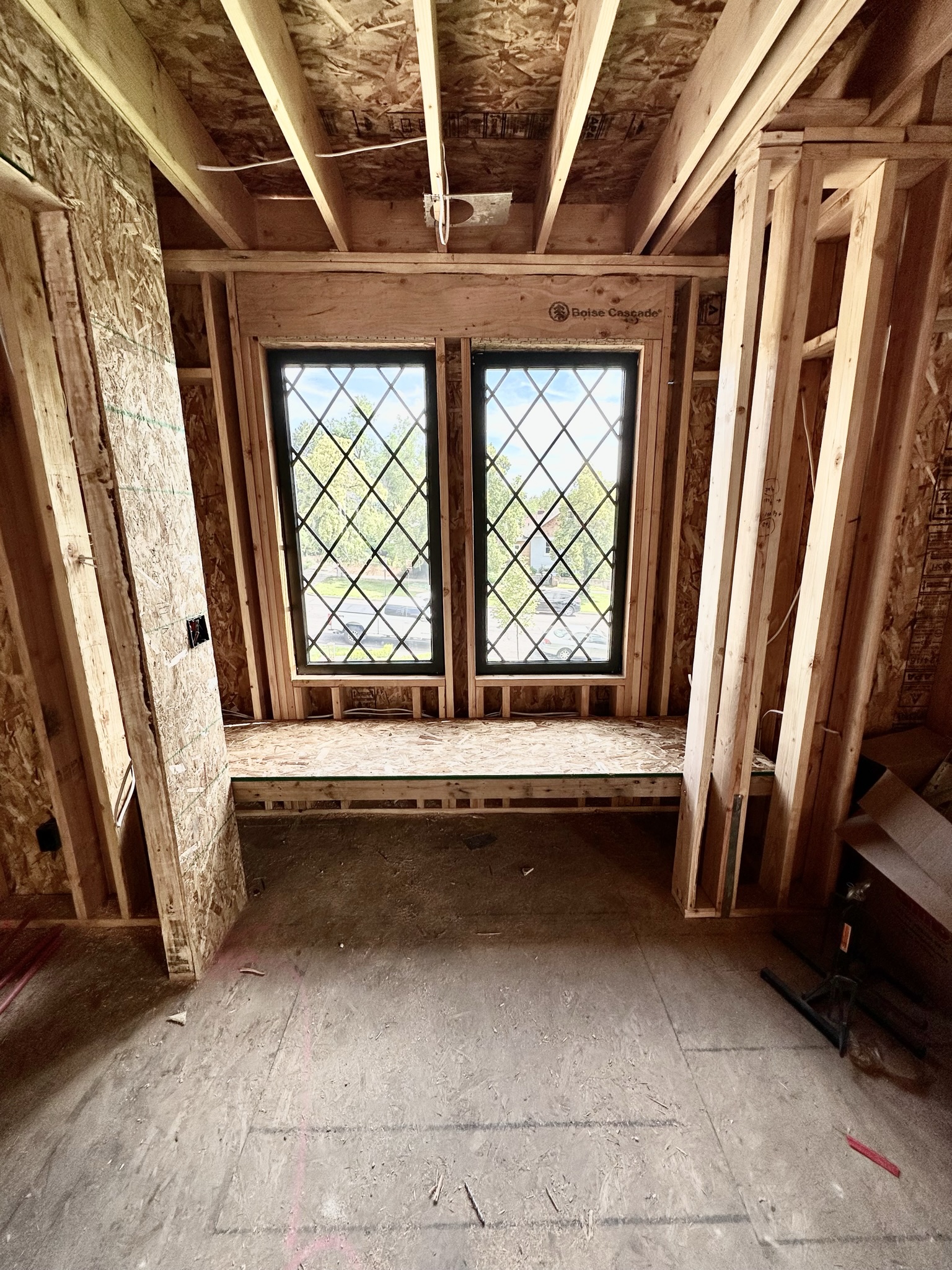 Diamond-pane leaded glass window installed in new framing with Boise Cascade LVL header — craftsmanship detail showing character-appropriate window choice