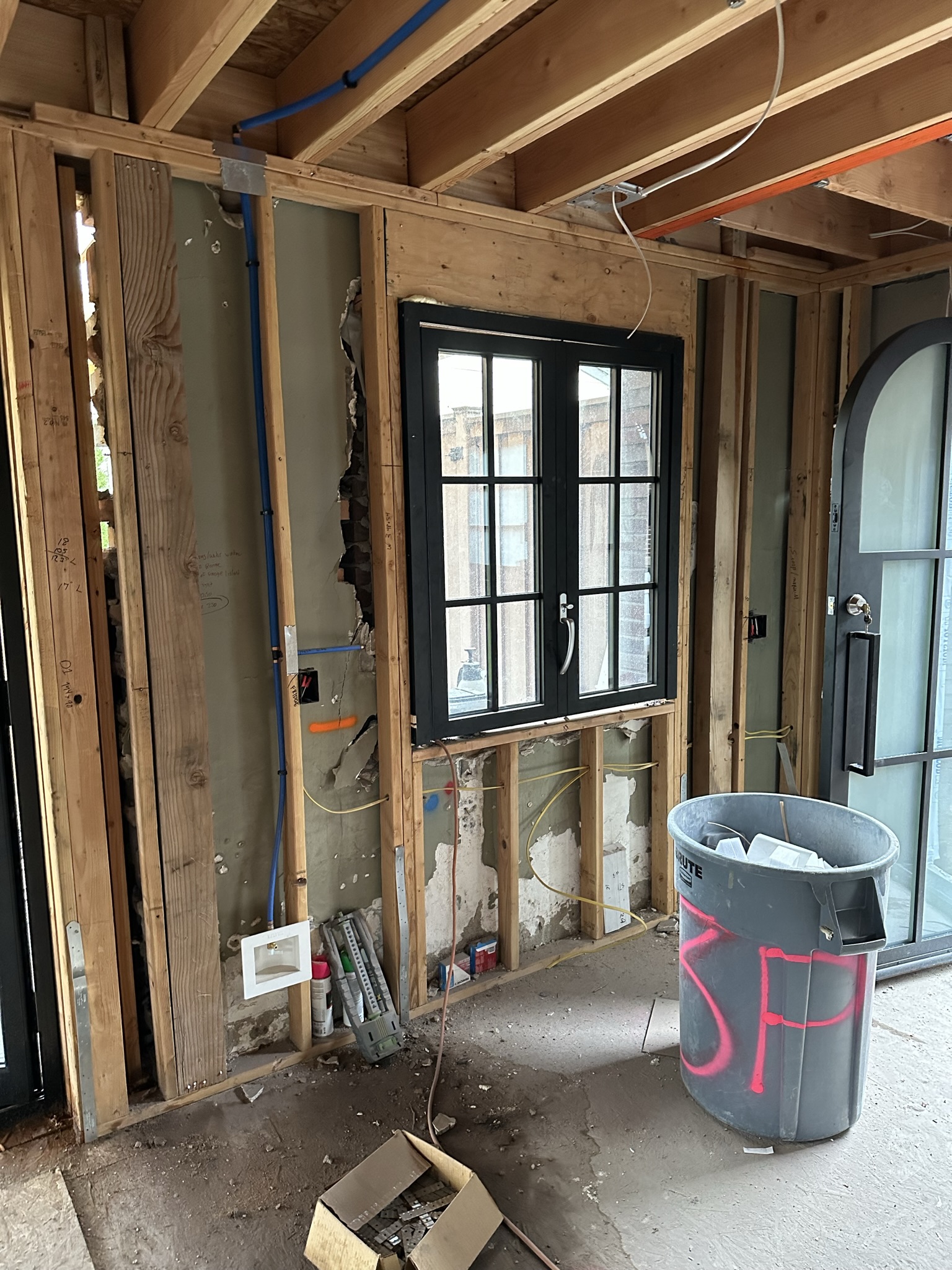 New interior framing with black-frame windows installed, natural light flooding the rebuilt space
