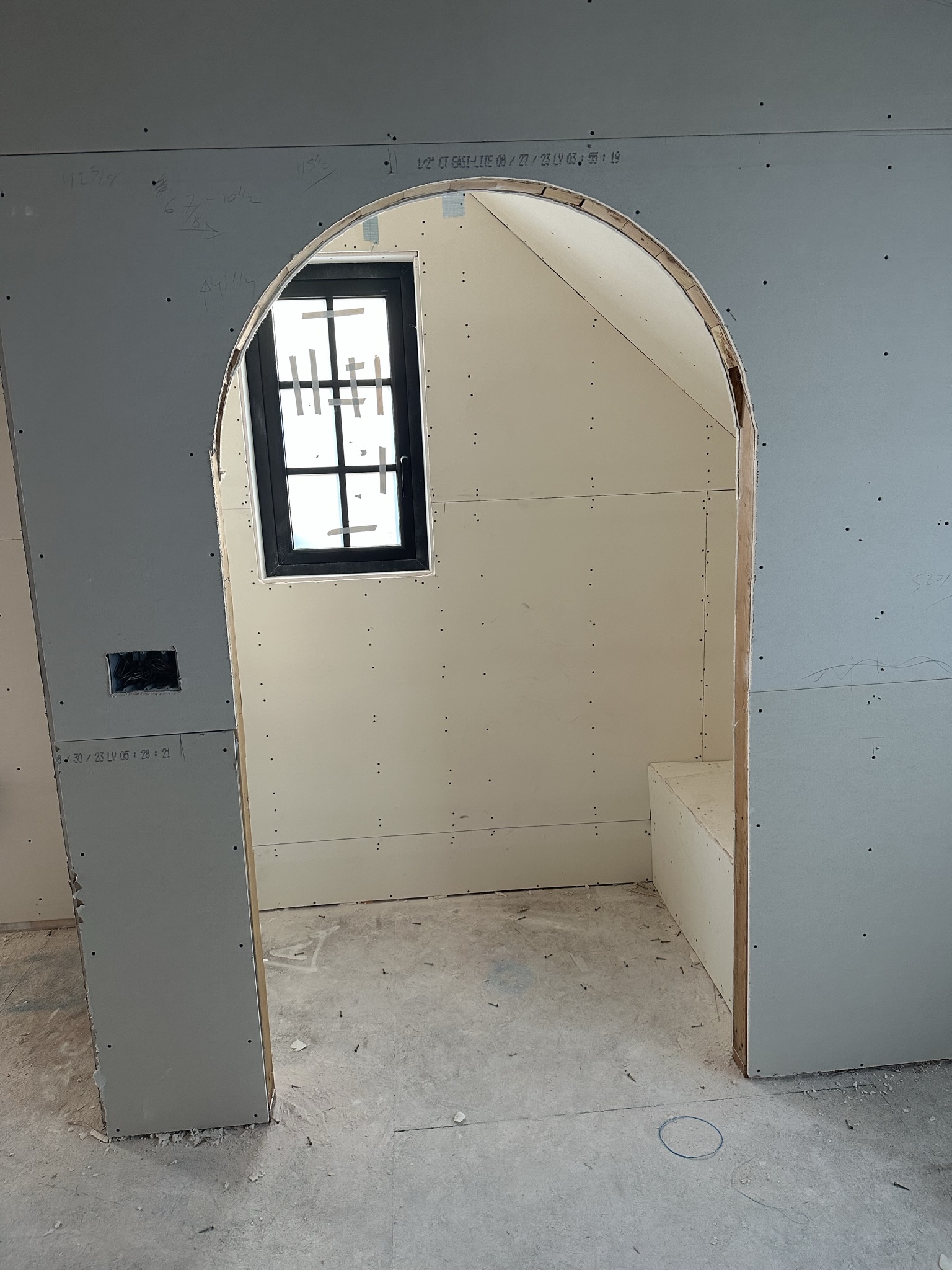 Custom arched alcove with drywall being finished — showing the precision of the framing and the craftsmanship in curved details