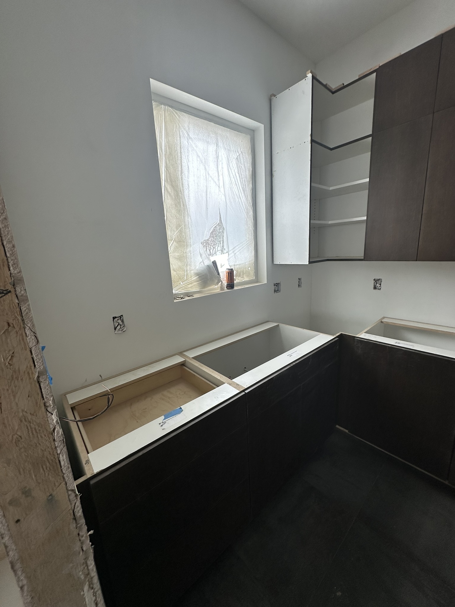 Bathroom vanity cabinets installed awaiting countertops, tile work in progress