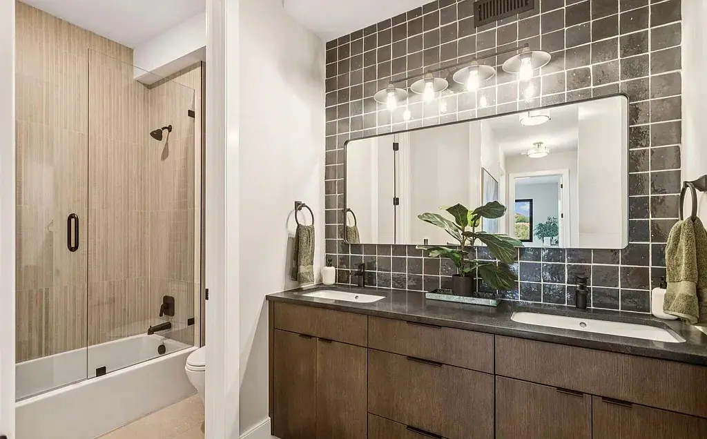Guest bathroom with dark tile and dual vanity