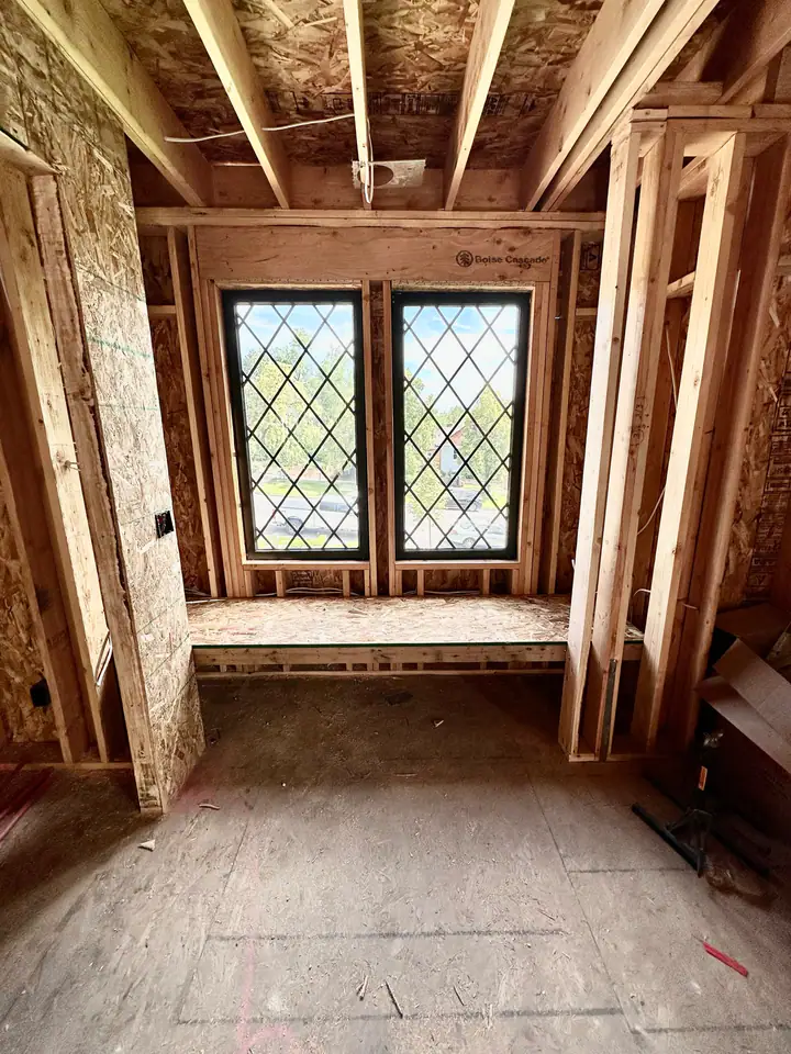 Diamond-pane leaded glass window installed in new framing with Boise Cascade LVL header — craftsmanship detail showing character-appropriate window choice