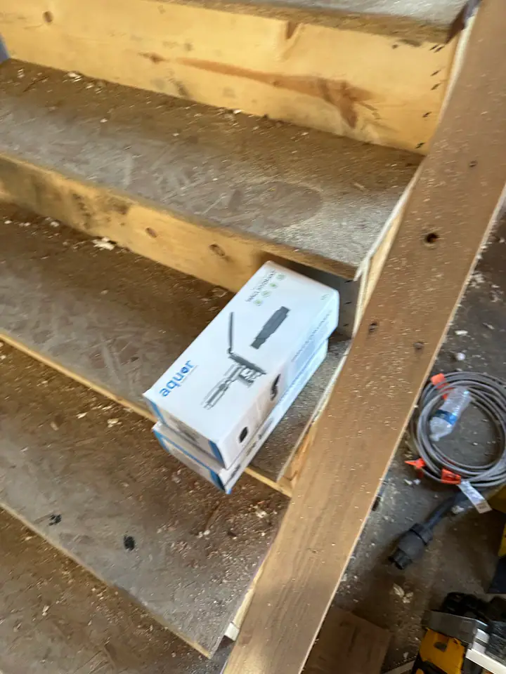 New staircase construction with solid stringers and OSB treads — connecting original main level to new second story addition
